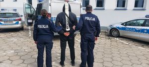 policjanci prowadzą zatrzymanego