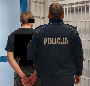 policjant i zatrzymanego. zdjęcie zrobione w pomieszczeniu komendy.