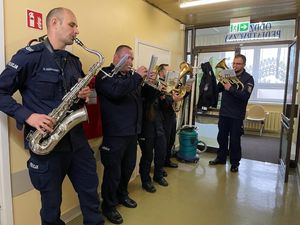 policyjni muzycy z instrumentami dętymi na korytarzu oddziału szpitalnego.