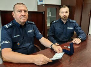 komendant policji oraz policjant siedzą w gabinecie, zdjęcie zrobione w czasie kiedy komendant pogratulował policjantowi za wyjątkową postawę.