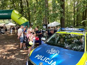 spotkanie policjanta z dziećmi, młodzieżą i mieszkańcami na pikniku organizowanym przez funkcjonariuszy straży leśnej.