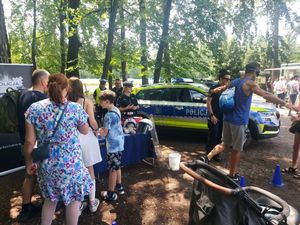 spotkanie policjanta z dziećmi, młodzieżą i mieszkańcami na pikniku organizowanym przez funkcjonariuszy straży leśnej.
