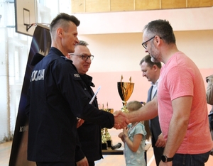 komendanci gratulują zawodnikom po zakończeniu turnieju  piłki nożnej na hali sportowej.