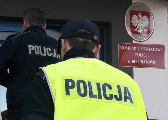 dwóch funkcjonariuszy wchodzących do budynku komendy.
