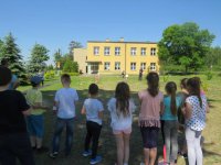 egzamin na kartę rowerową, na placu przed szkoła zgromadzone dzieci . uczeń pokonuje tor przeszkód