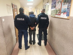Policjanci prowadzą zatrzymanego