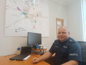 umundurowany policjant siedzi przy biurku.