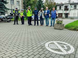 wszyscy uczestnicy przedsięwzięcia stoją w tle przed piktogramem.