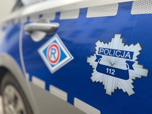 Widoczny bok radiowozu z napisem Policja.