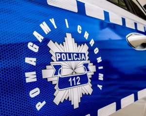 Napis na drzwiach radiowozu &quot;Pomagamy i chronimy&quot;.