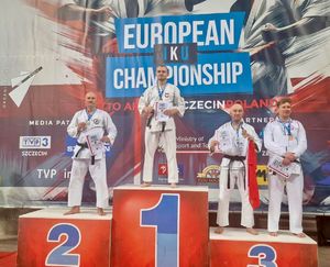 Policjant na podium, zdjęcie przedstawiające umundurowanego policjanta z dwoma medalami.