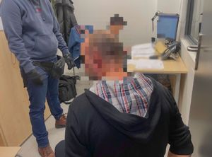 Zatrzymany mężczyzna, obok niego stoi policjant po cywilnemu.