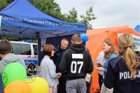 Młodzież zainteresowana pracą w Policji podeszła do stoiska z ulotkami.