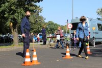 Policjant nadzorujący panią pokonującą slalom w alkogoglach