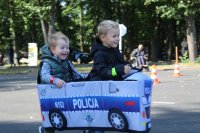 Szczęśliwe dzieci w autochodziku z napisem policja