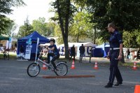 Dziecko na rowerze i w kasku pokonujące tor na miasteczku ruchu drogowego