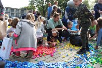 uczestnicy pikniku pomagający zbierać nakrętki dla chorej Mai