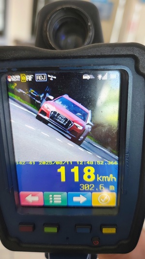 Urządzenie mierzące prędkość. Na ekranie urządzenia widać nadjeżdżający samochód i wskazanie, że pojazd jedzie 118 km/h.