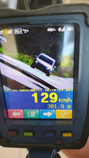 Urządzenie mierzące prędkość. Na urządzeniu widać nadjeżdżający samochód i wskazanie prędkości samochodu 129 km/h.