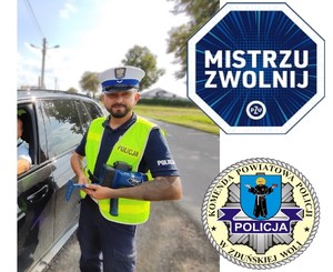 Policjant stoi obok samochodu, pozuje do zdjęcia.