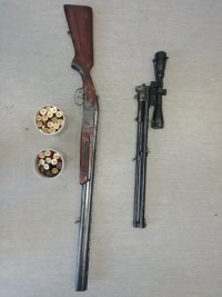 zdjęcie przedstawia zabezpieczoną broń palną, typu strzelba dubeltówka oraz amunicję