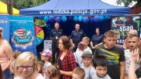 zdjęcia przedstawiają piknik edukacyjny w Mroczkowie. Widać na nich dzieci skupione wokół namiotu Policji, umundurowanych policjantów, scenę na której odbywają się występy artystyczne najmłodszych. Fotografia chłopca w kasku policyjnym z tarczą na tle baneru Zostań  Policjantem, Zbiorowe zdjęcia z uczestnikami pikniku.