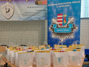 baner z logo policji, torby z upominkami z napisem powiat opoczyński.
