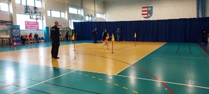 policjant w mundurze, dziecko biegnie wokół pachołków.