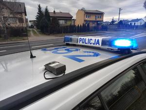 dach radiowozu policyjnego, włączone niebieskie światłą, na dachu leży urządzenie do badania stanu trzeźwości.
