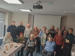 policjanci stoją razem ze starszymi mężczyznami i kobietami.