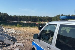 radiowóz stoi przy zbiorniku wodnym.
