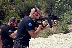 Policjanci trenują strzelanie z karabinków podczas misji zagranicznej w Kosowie.